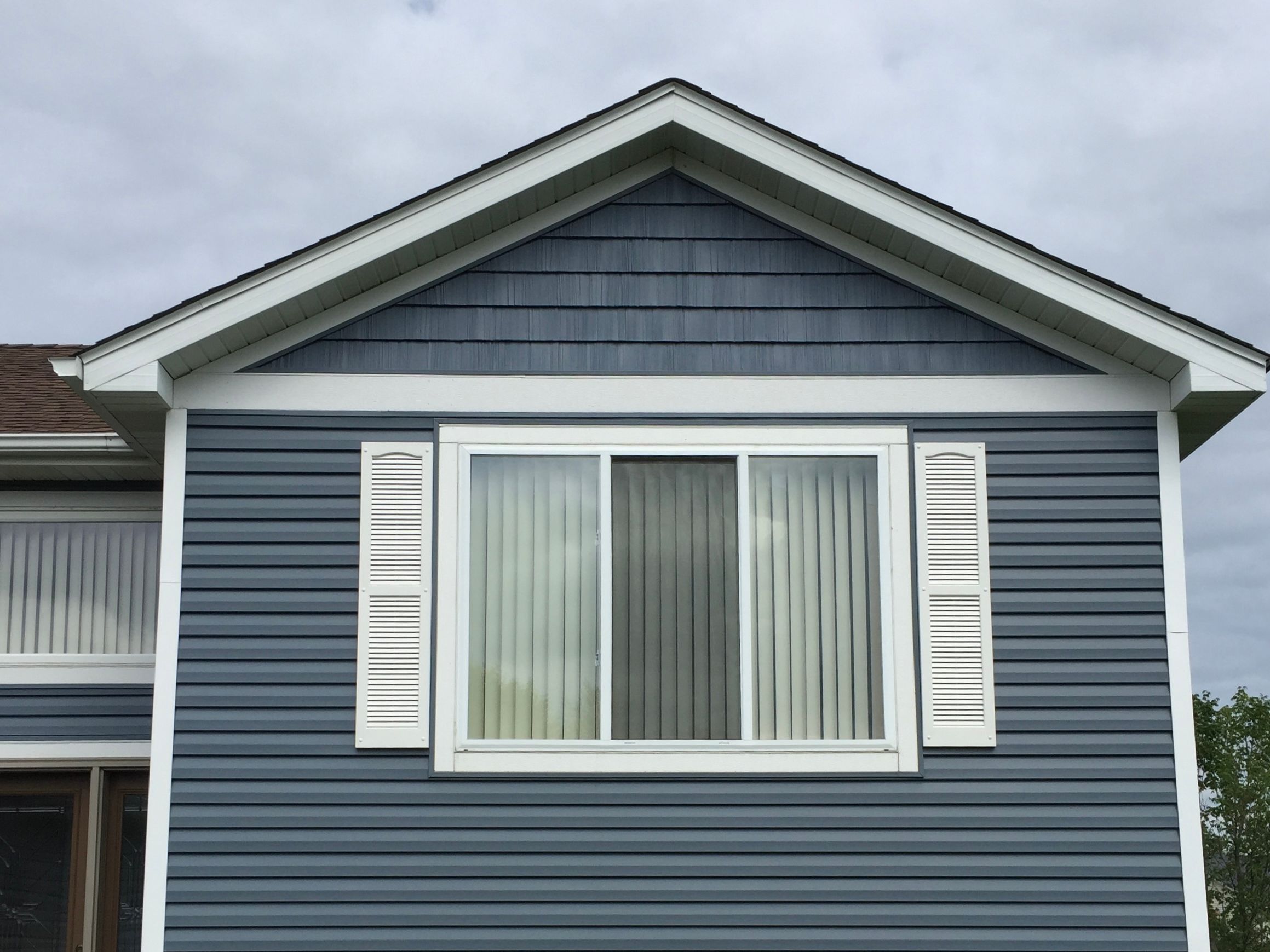 Blue lap siding with white shutters and trim