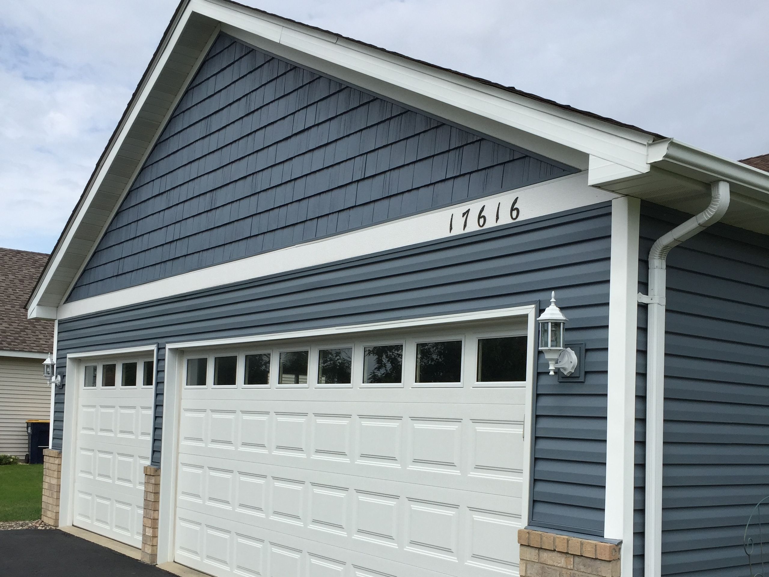 Gutter and downspout on a blue-sided house