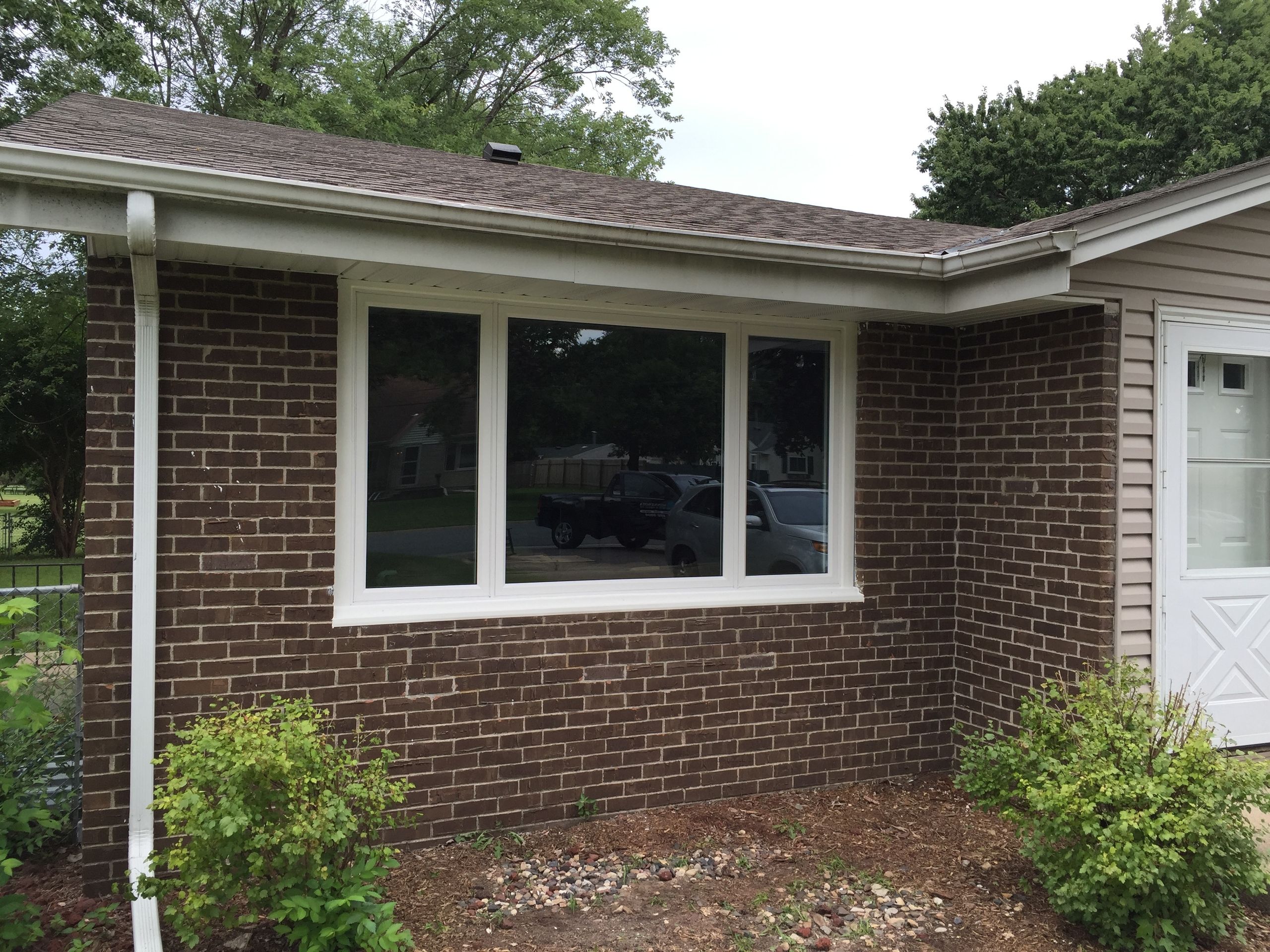 Picture window set into a brick wall beside a downspout