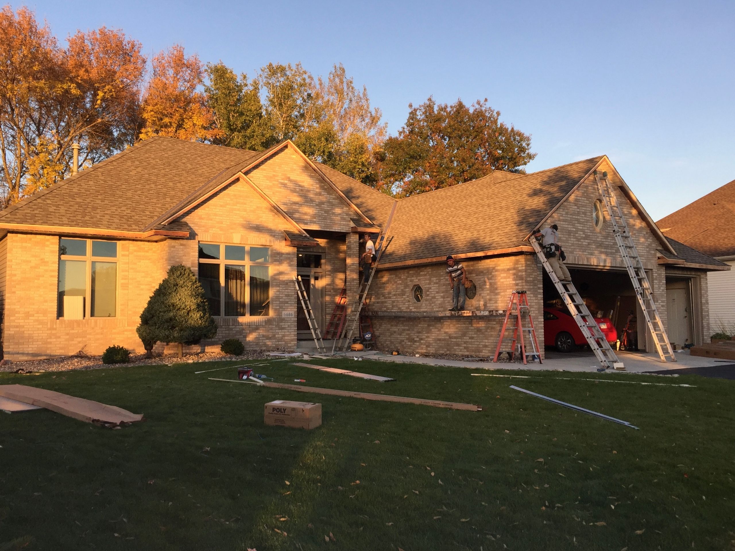 Roofing crew finishing a roof at sunset
