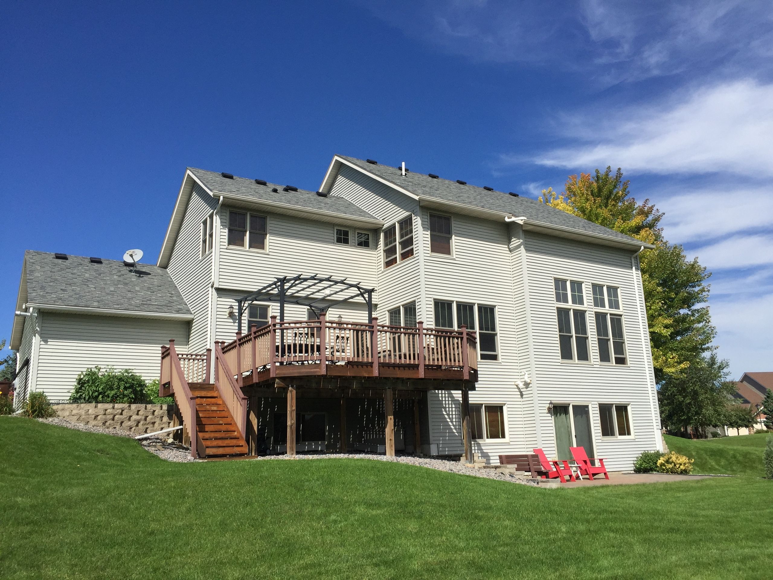 Rear of a two-story home with new gutters and a deck