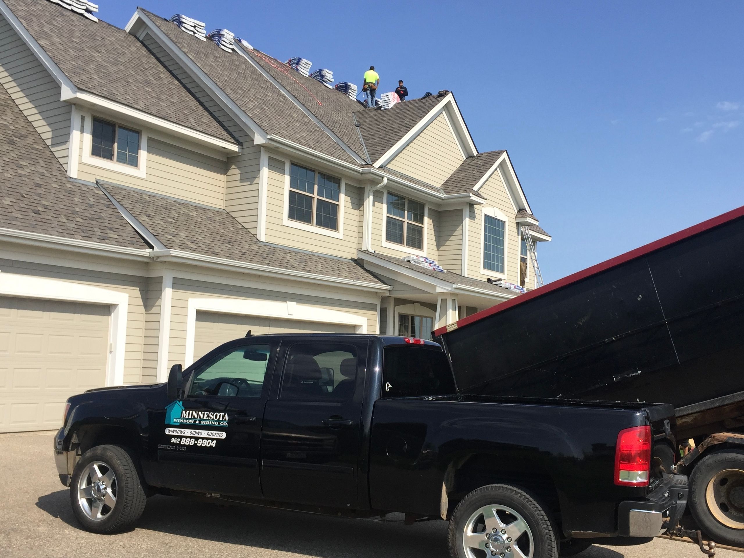 Roofing crew and work truck at a residential job