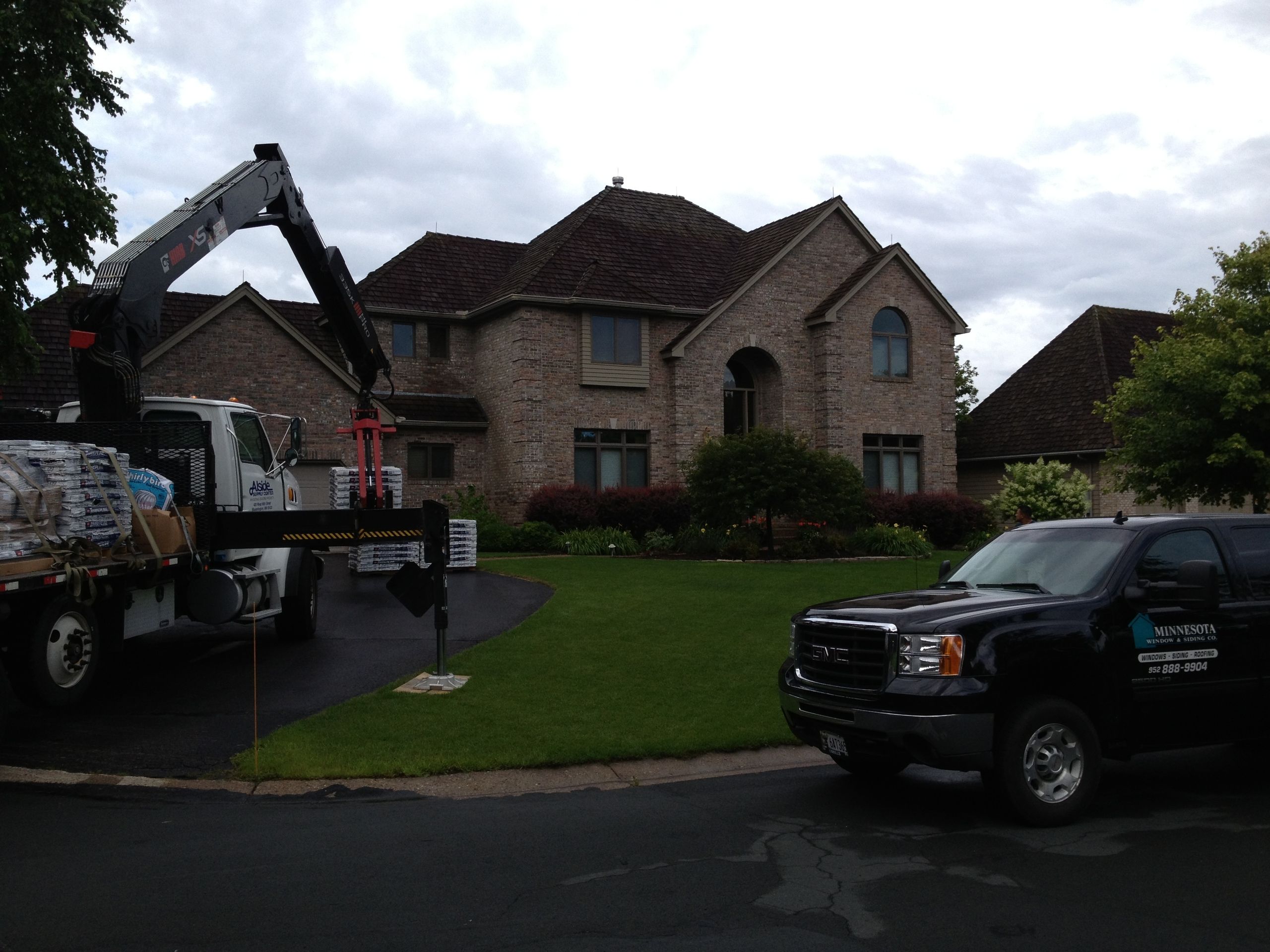 Material delivery staged at a brick two-story home