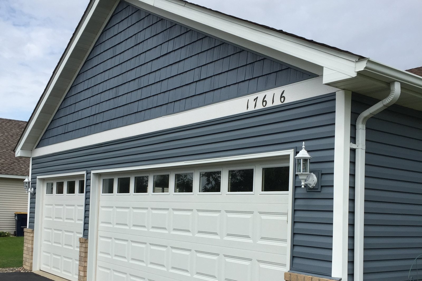 Oversized downspout on a blue-sided house