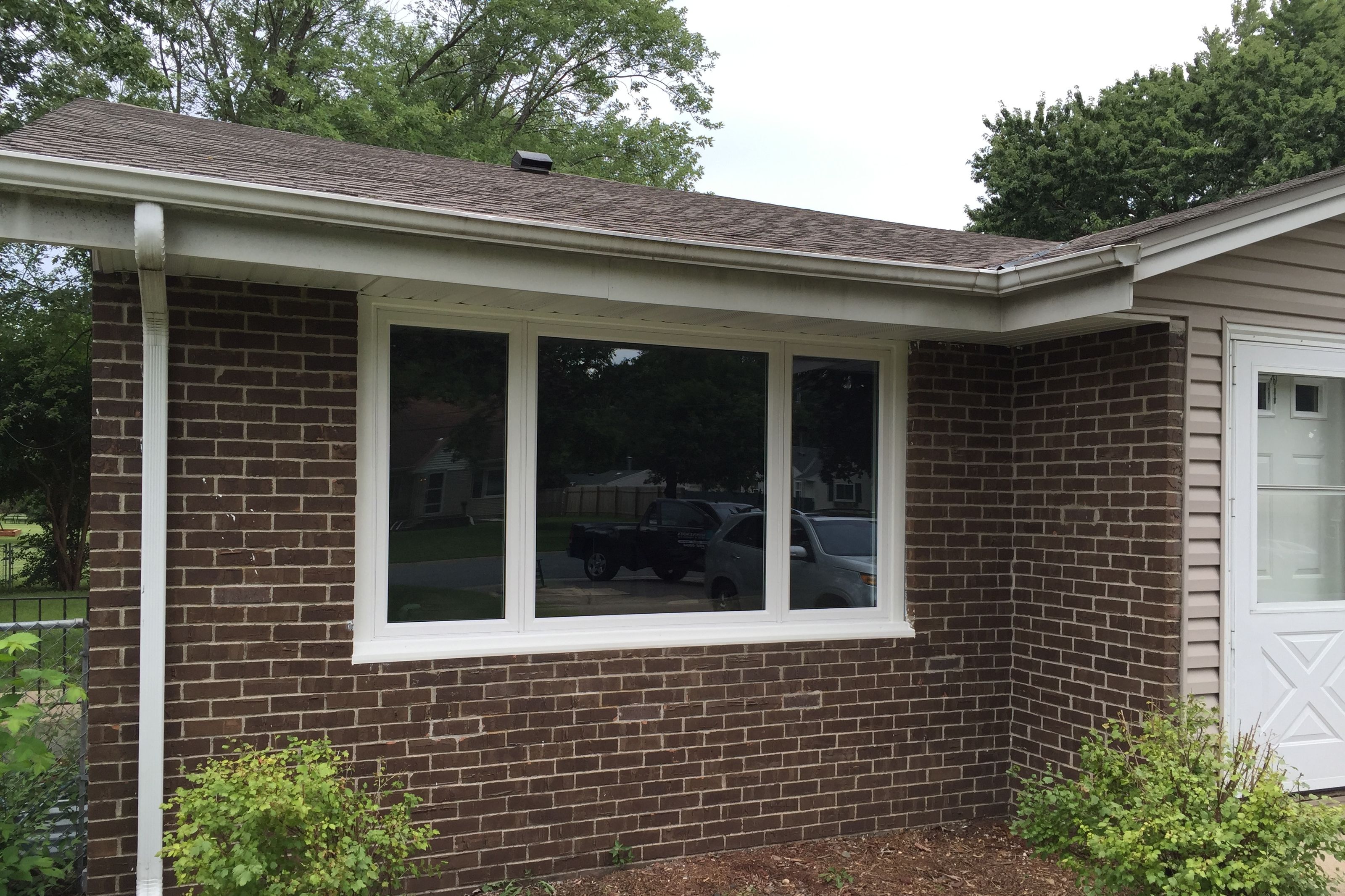 New white fascia and vented soffit running the eave of a brick rambler
