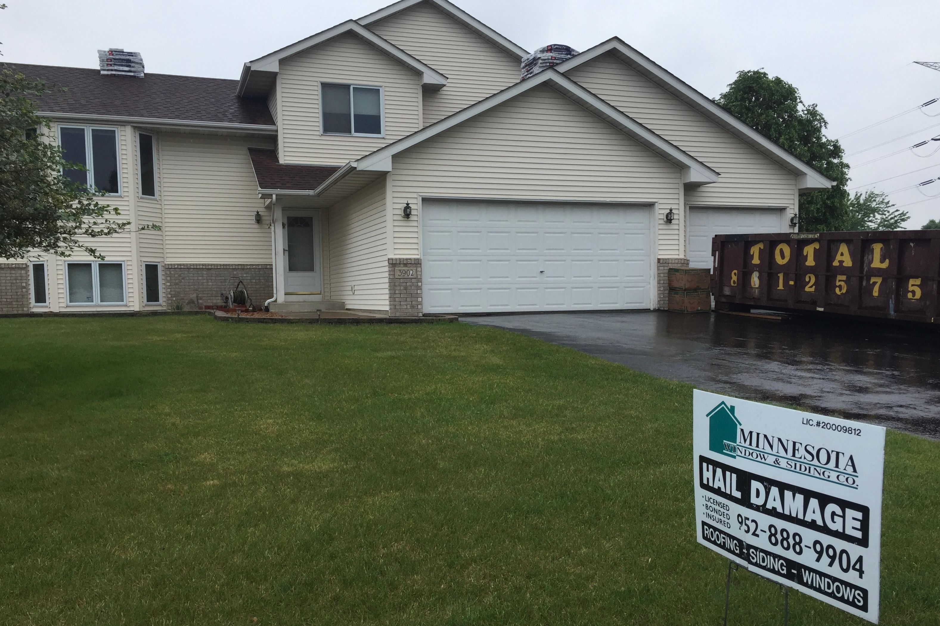 Company yard sign in front of a home after a hailstorm