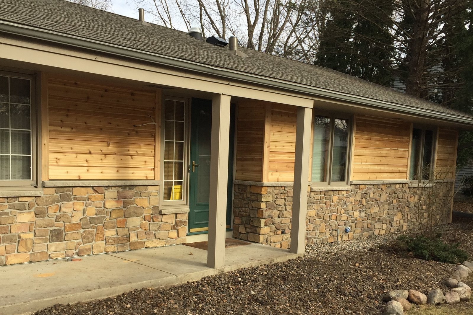 Natural cedar siding over a stone base on a ranch home