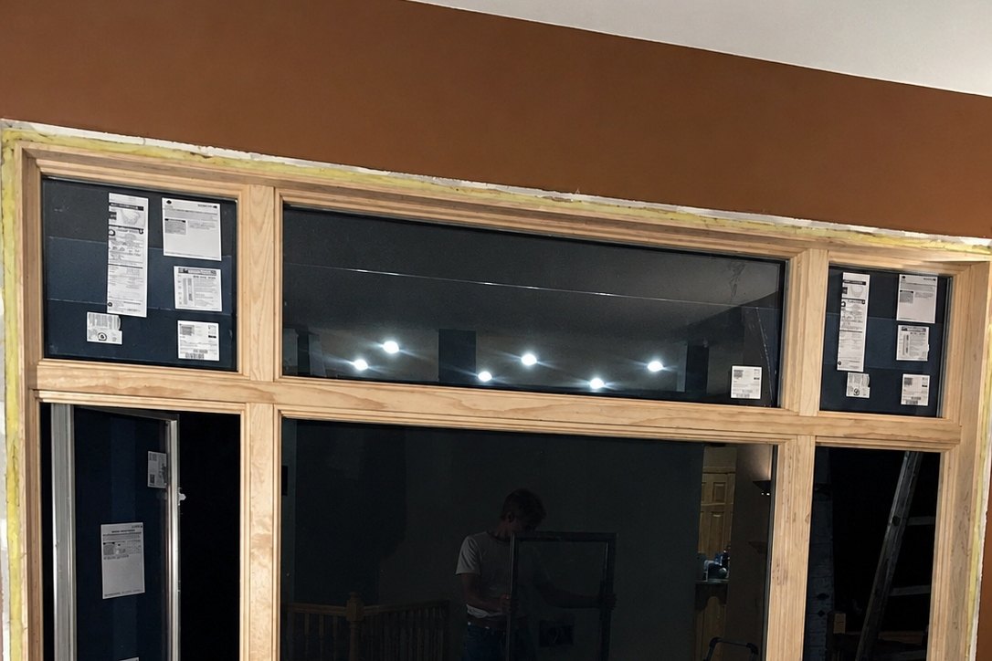 New picture window with a transom and side units, labels still on, before the interior trim goes back